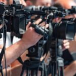 Tiny Nation Defies EU Push television cameras on tripods at a media event
