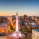 Washington Monument in a city square at dusk