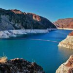 Farm Costs Surge After River Ruling Reservoir between rugged desert cliffs with stark white shoreline
