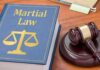 Law book with scales symbol beside a judge's gavel on a desk