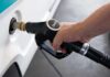 A hand holding a diesel fuel nozzle while refueling a vehicle
