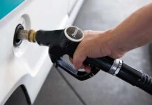 A hand holding a diesel fuel nozzle while refueling a vehicle