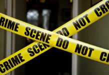 Children Among Dead In Erie Horror Yellow crime scene tape crossing a doorway