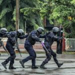 Police tactical team advancing in rain