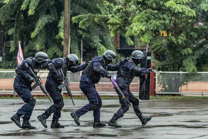 shutterstock_1115325713 Police tactical team advancing in rain