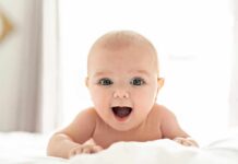 Smiling baby lying on a bed
