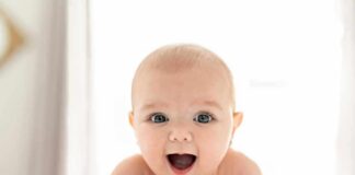 Smiling baby lying on a bed