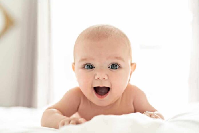 Smiling baby lying on a bed