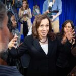 Kamala Harris speaks to a crowd as Maya Harris stands nearby