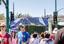 Crowd walking past a Disneyland Resort entrance sign