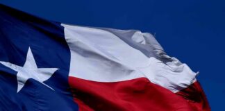 Texas flag waving against a clear blue sky