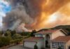 Suburban house under towering wildfire smoke plume
