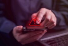 Person tapping smartphone with red warning icon