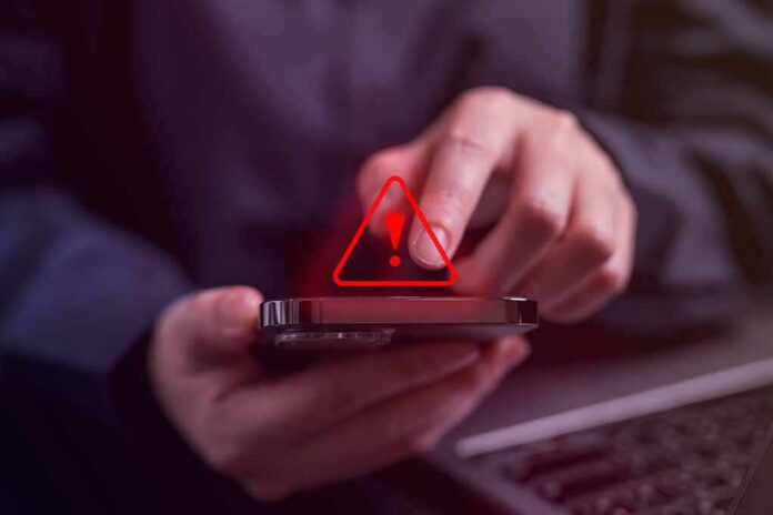 Person tapping smartphone with red warning icon