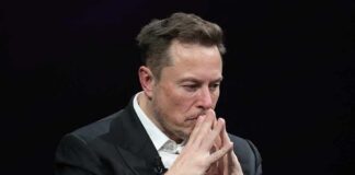 Elon Musk seated with hands steepled in thought