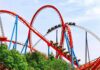 Colorful roller coaster with riders on a sunny day