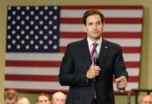 man in suit speaking into a microphone