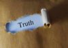 Torn brown paper revealing the word 'Truth' on white background