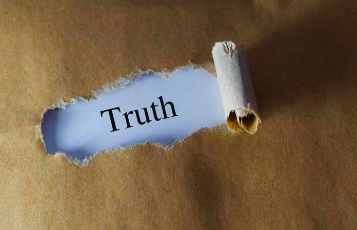 shutterstock_384729706 Torn brown paper revealing the word 'Truth' on white background