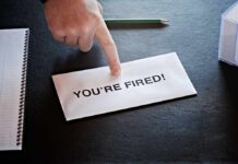 TOP BRASS Busted For What He FAILED Hand pointing at a termination letter on a desk