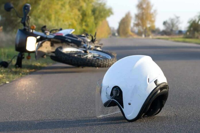 shutterstock_739145995 White motorcycle helmet on road with fallen bike in background